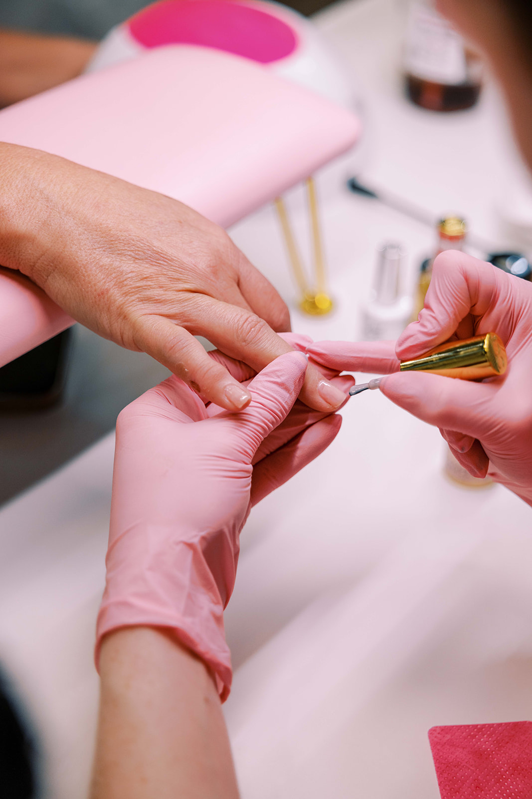Freshly manicured nails with light pink polish resting on a towel