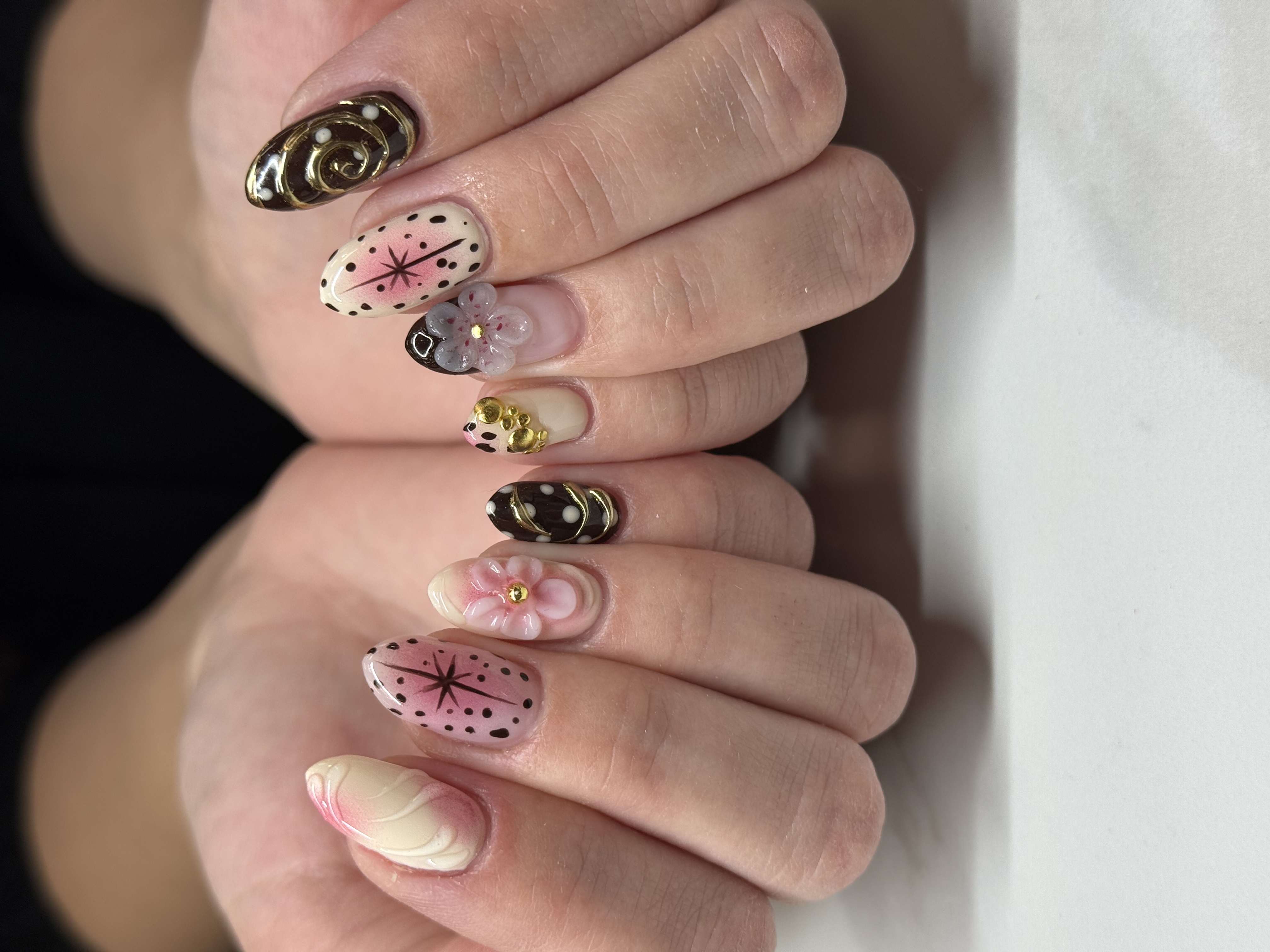 Freshly manicured nails with gold-tipped polish resting on a towel
