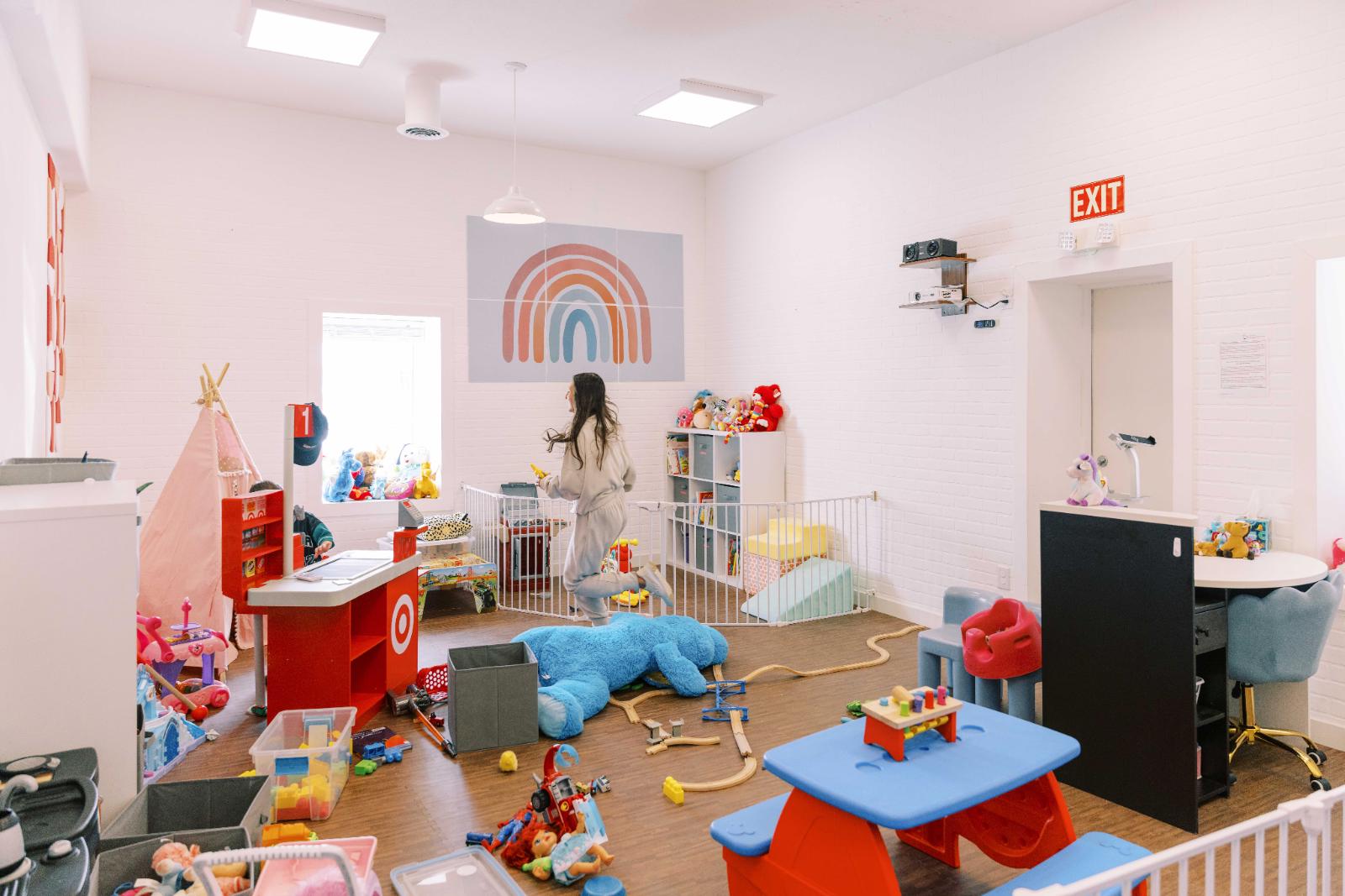 Children playing happily in the supervised Kid Corner at Mom’s Oasis