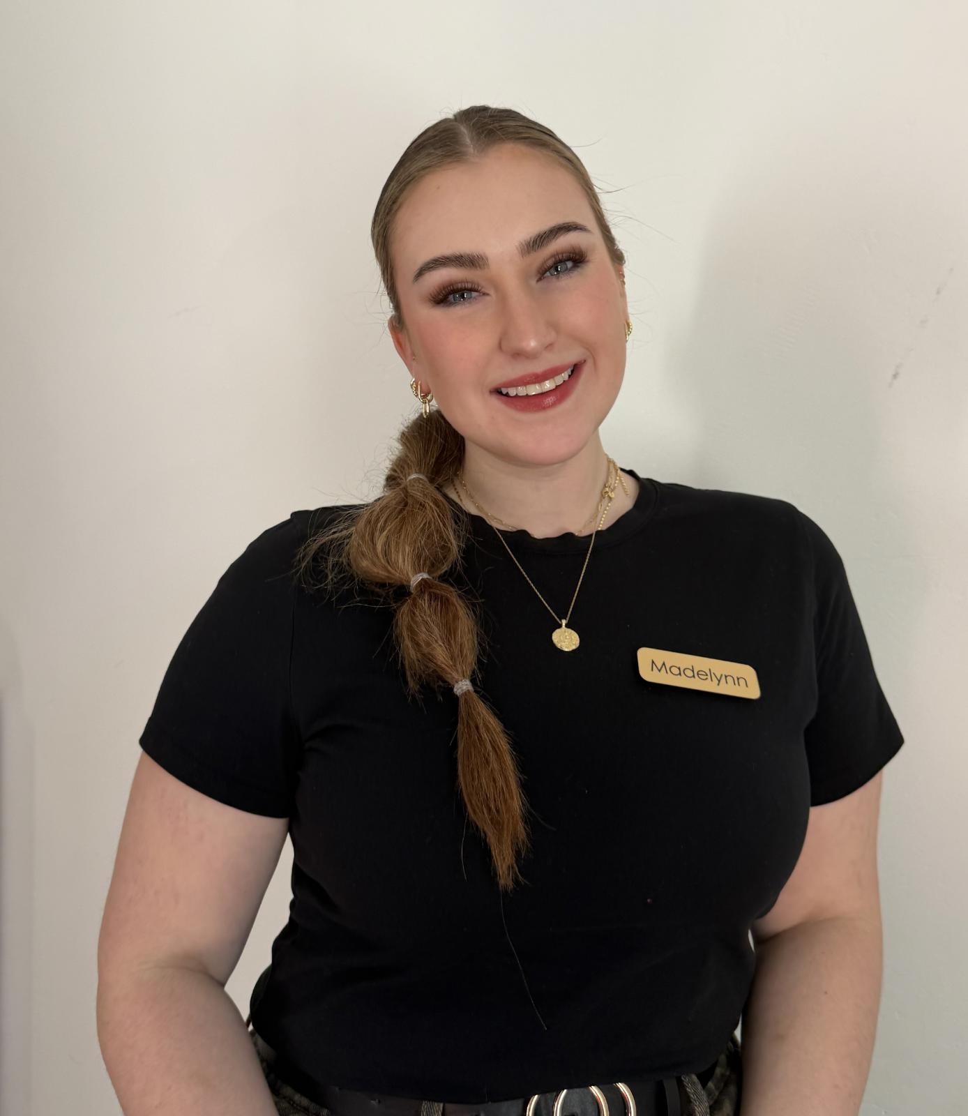 Madelynn, CEO of Mom’s Oasis, smiling in a professional portrait setting